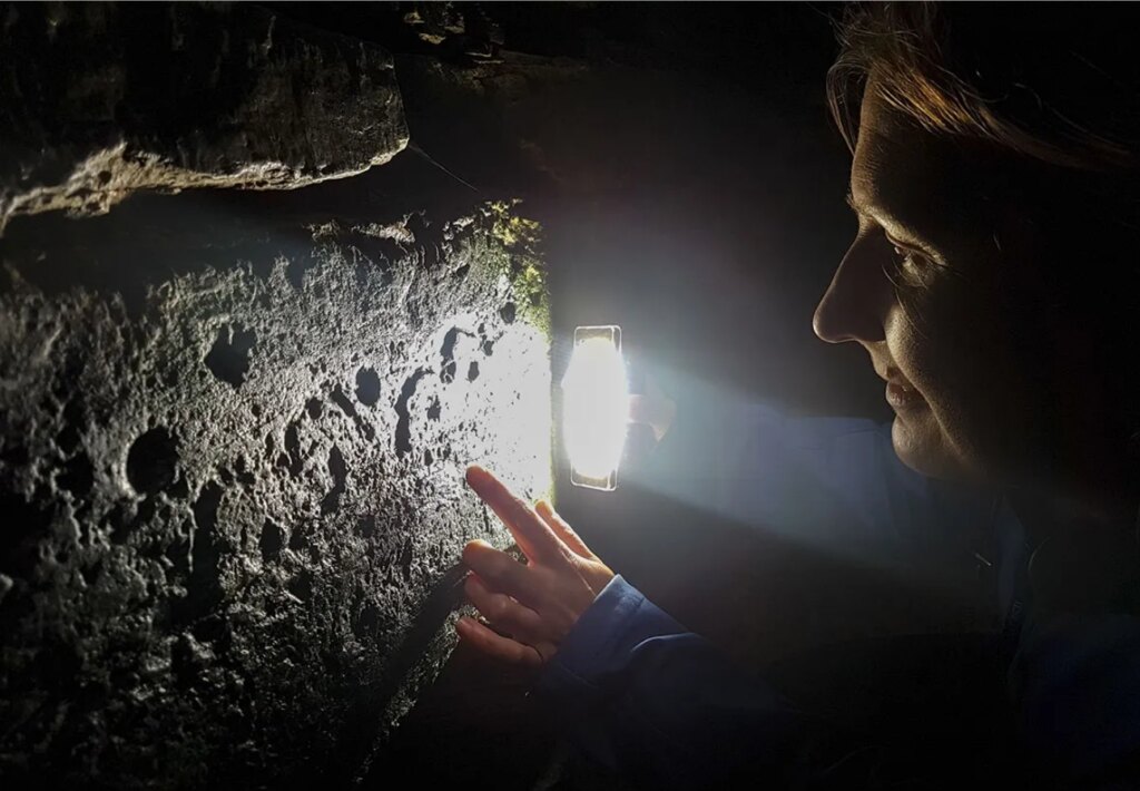 Antonia Thomas looking at rock art